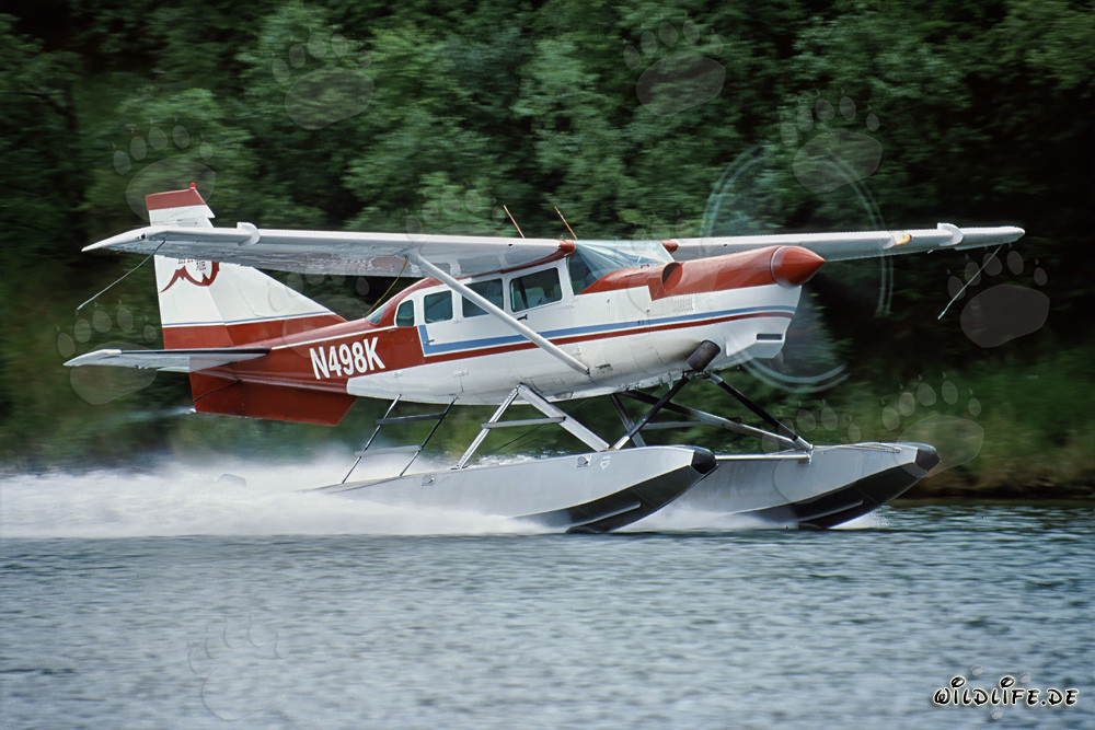 Floatplane taking off into the sky over Alaska