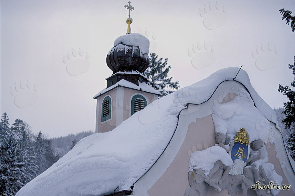 Capilla de montaña nevada idílica en los Alpes bávaros