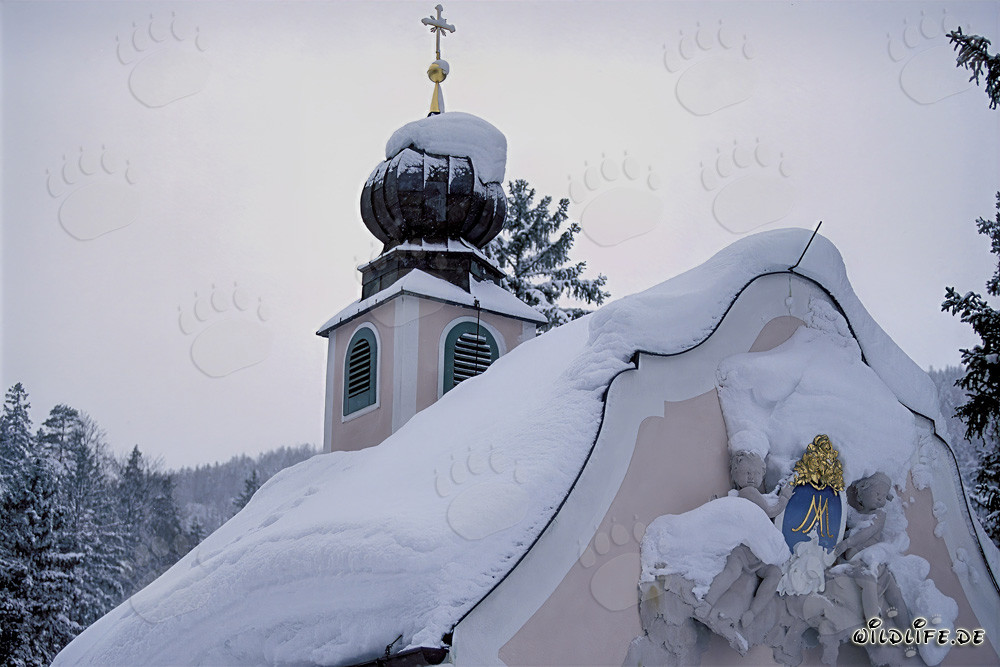 Idyllic snow-covered mountain chapel in the Bavarian Alps