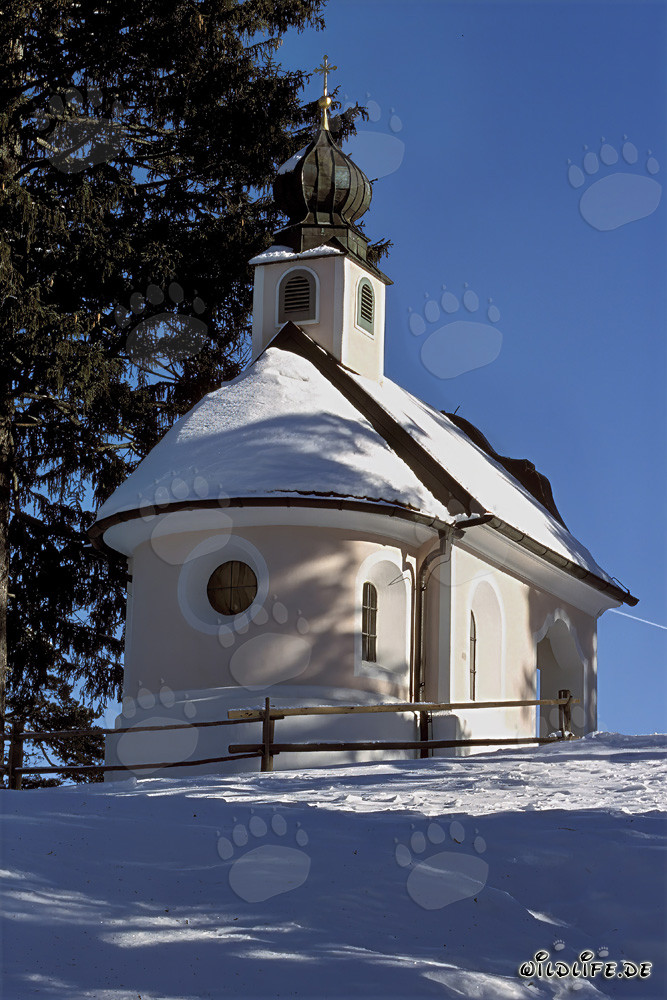 Romantische Weihnachtskapelle in den verschneiten Bergen von Bayern