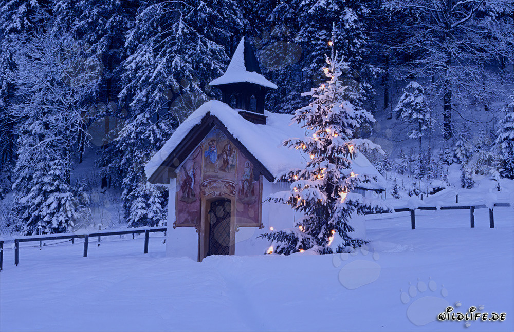 Noël en montagne avec chapelle traditionnelle et sommets enneigés