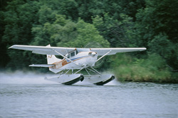 Floatplane taking off at Lake Coville in Alaska
