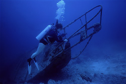 Fascinating diver exploring mysterious wreck underwater in the Maldives