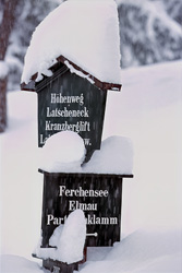 Idyllic snow-covered sign in the winter forest of Mittenwald, Bavaria