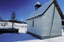 Idyllic winter landscape with snow-covered chapel in Bavaria