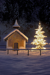 Romantic chapel and festive Christmas tree in the wintry Bavarian mountains