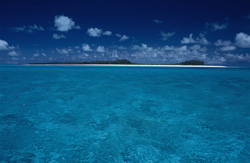 A fascinating South Sea dream motif: An island in the Midway Atoll with dense vegetation, snow-white beach, blue lagoon and deep blue sky.