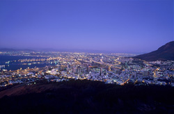 Atardecer mágico sobre Ciudad del Cabo con vista al mar de luces de la ciudad