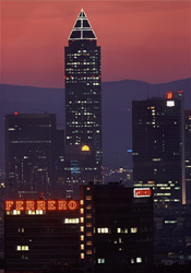Der leuchtende Messeturm vor dem Abendhimmel von Frankfurt